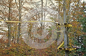 Rope bridge in adventure treetop park for tree climbing and sport, arborismo or accrobranche ropes courses, zip wires