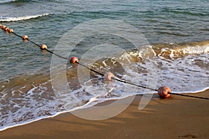 Rope with buoys to fence off a safe swimming area on the beach