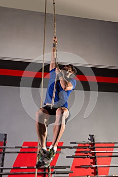 Rope Climb exercise man workout at gym