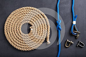 Rope coiled into a circle, knots and shackles. Accessories for sea wolves on the table