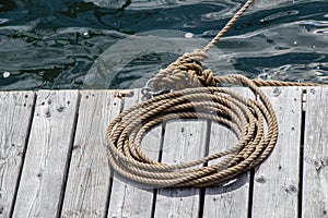 Rope coiled on a wooden dock securing a vessel