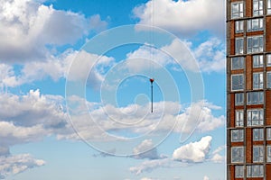 The rope of a construction cargo crane on a background of blue sky with clouds