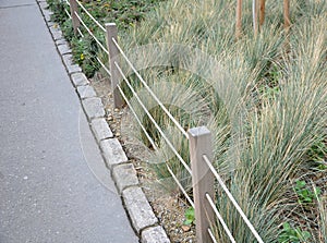 rope fence park path rope protect entrance people walking steps enter fences wooden asphalt ornamental grass coble stones flower