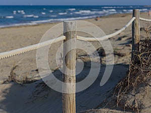 Rope fence on the sandy beach of La Mata. Sunset on the beach. Blurred unfocused blue sea background 04