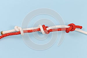 Rope fisherman knot with stopper knots on a blue background
