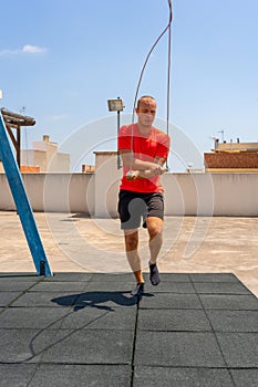 Rope jumping. Young sportsman having training and doing exercise outdoors. Sport, fitness, street workout concept