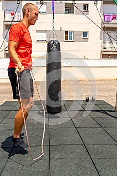 Rope jumping. Young sportsman having training and doing exercise outdoors. Sport, fitness, street workout concept.