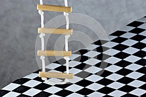 Rope ladder and floor background black and white square cage.Rope ladder-wooden steps, convenience,simplicity,compactness,