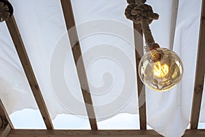 Rope light bulb over canvas pergola cover