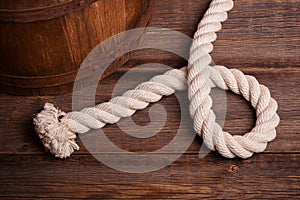 A rope lying near an old wooden barrel