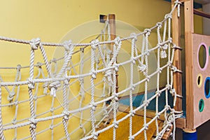 Rope net tied for climb. Indoors playground.