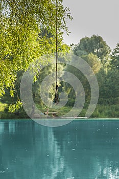 a rope with a noose hangs over a blue lake