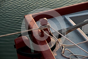 Rope and an old mooring bollard in port, up-close and in detail of the old red boat