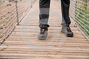 Rope park. A woman in trekking shoes runs a route in a rope park. Close-up of legs.