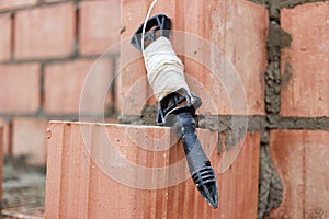 Rope plumb for even brickwork. Compliance with the correct laying of walls and corners of ceramic bricks. Bricklayer\'s tool