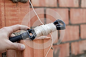 Rope plumb for even brickwork. Compliance with the correct laying of walls and corners of ceramic bricks. Bricklayer's tool