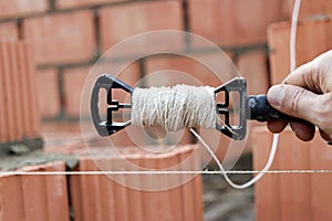 Rope plumb for even brickwork. Compliance with the correct laying of walls and corners of ceramic bricks. Bricklayer's tool