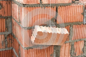 Rope plumb for even brickwork. Compliance with the correct laying of walls and corners of ceramic bricks. Bricklayer\'s tool