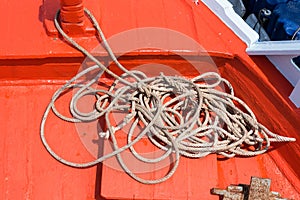 Rope and Small anchor on board ship deck.