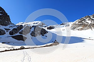 Rope team having a break on glacier Sexegertenferner and mountain snow panorama with blue sky in Tyrol Alps, Austria