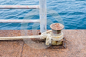 Rope thick tied with steel pier for boat photo