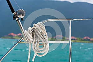 A rope tied around a lifeline and a fishing rod on a yacht