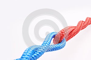 Rope, ties and connection with color in knot, link or loop together on white background in collaboration. Blue, red and