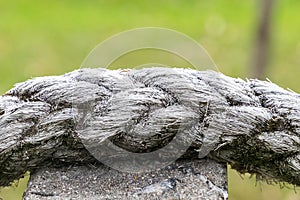 A rope is wrapped around a stone, and it is covered in frost photo
