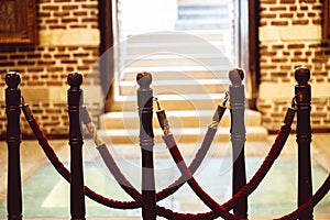 roped walkway leading into a building with brick walls and open door photo