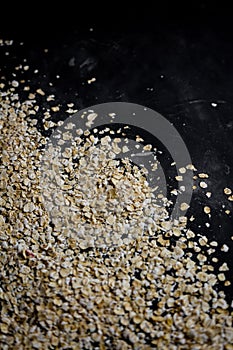 Roper nutrition, oatmeal flakes scattered on a dark table
