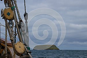 Ropes of an ancient whaler in the foreground and in the background the island where the puffins live photo