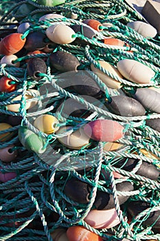Ropes with buoys from fishing nets in a pile on the waterfront of fishing port
