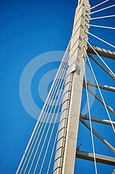 Ropes of a cable-stayed bridge against a blue sky