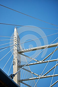 Ropes of a cable-stayed bridge against a blue sky