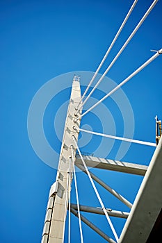Ropes of a cable-stayed bridge against a blue sky