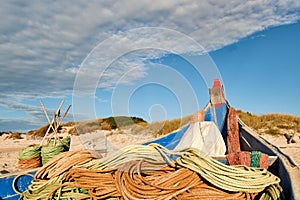 Ropes and colorful fishing boats on the sand