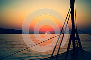 Ropes on a Sailboat With Sunrise and Islands in the Background