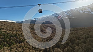 Ropeway cabin over yellow winter pine forest snow mountain valley landscape aerial panorama view