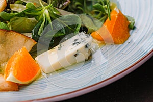 Roquefort cheese cut out with oranges and greens. Appetizer, salads. Healthy food. Restaurand and homemade food.