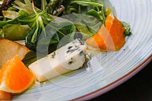 Roquefort cheese cut out with oranges and greens. Appetizer, salads. Healthy food. Restaurand and homemade food.