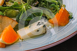 Roquefort cheese cut out with oranges and greens. Appetizer, salads. Healthy food. Restaurand and homemade food.