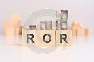 ROR concept with cubes and coins on light background