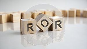 ROR - Rate Of Return acronym concept on cubes, gray background