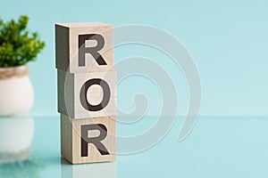 ROR - Rate Of Return. Wooden blocks with the word ROR, blue background