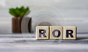 ROR - word on wooden cubes against the background of a light board with beautiful divorces and a cactus