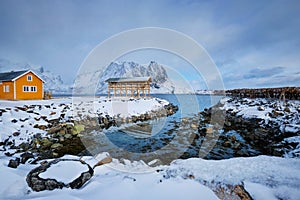 Rorbu house and drying flakes for stockfish cod fish in winter. Lofoten islands, Norway