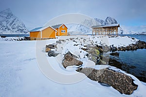 Rorbu house and drying flakes for stockfish cod fish in winter. Lofoten islands, Norway