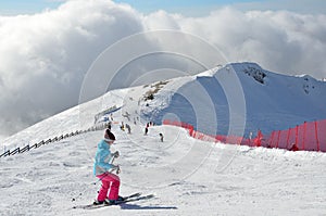 Rosa Khutor, Sochi, Russia, January, 26, 2018. Young woman down from the ski slope `Triton` on ski resort Rosa Khutor