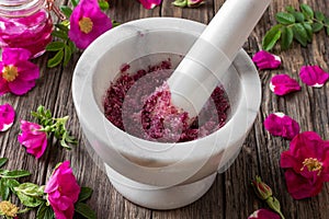 Rosa rugosa petals cruhed with sugar in a mortar