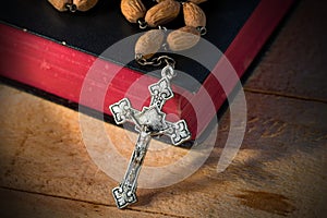 Rosary Beads and Holy Bible on Wooden Table